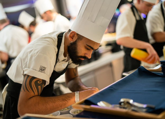 A Constellation chef preparing food in the kitchen at Tottenham Hotspur's stadium.